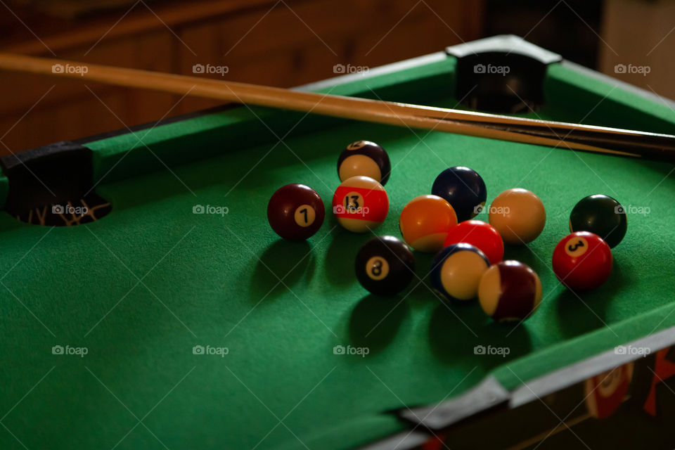 Pool table in the dark room with round balls on it