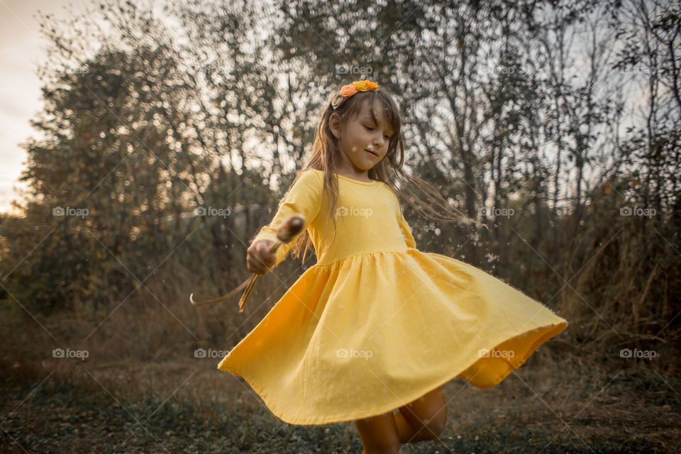 Little girl in yellow dress outdoor portrait at sunset 