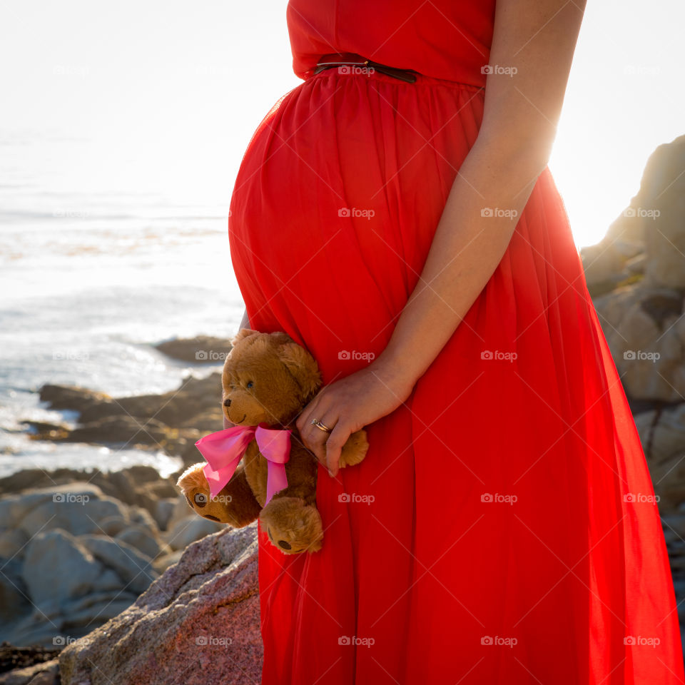 pregnant woman stands by the ocean