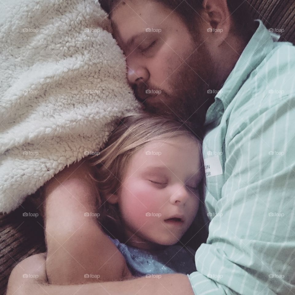Rainy Day Napping. A father naps with his daughter after school.