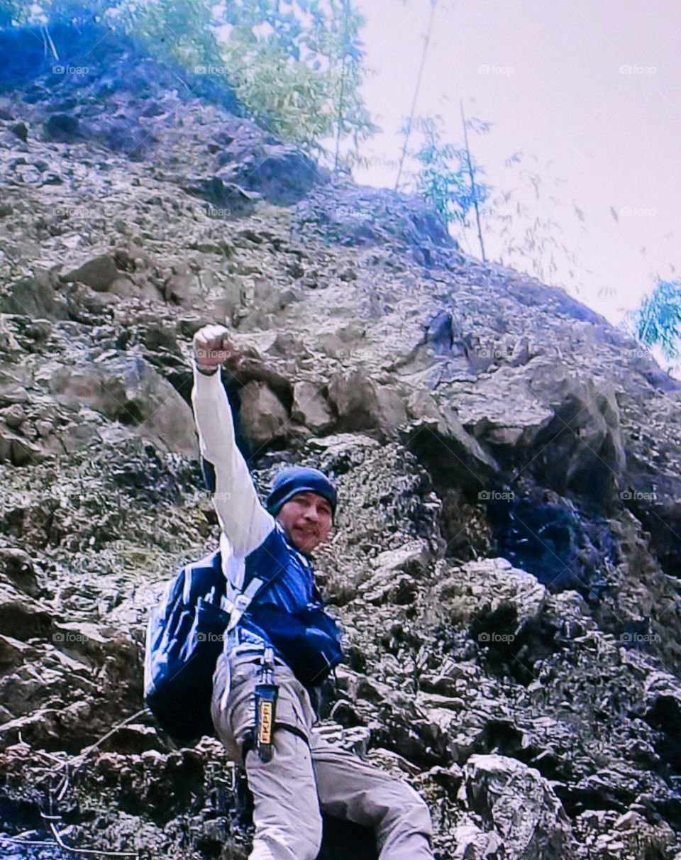 A cool mountain peak with a gust of wind blowing after several stages finally a target was reached safely by being greeted by the wind on a steep mountain peak