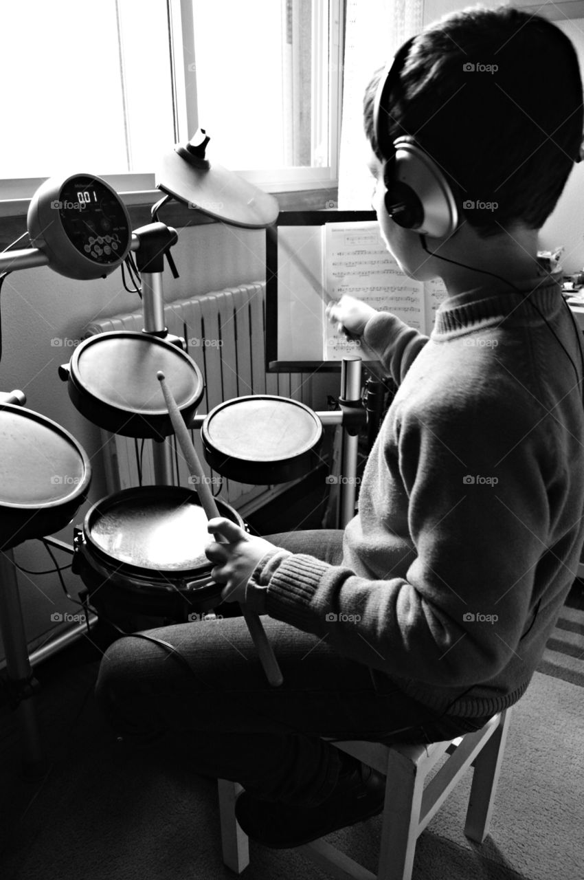 Young drummer. My son practising with his electronic drum set