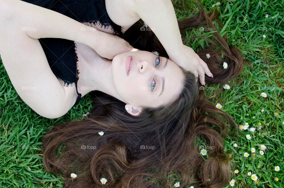 Portrait of a woman brunette on a background of daisies