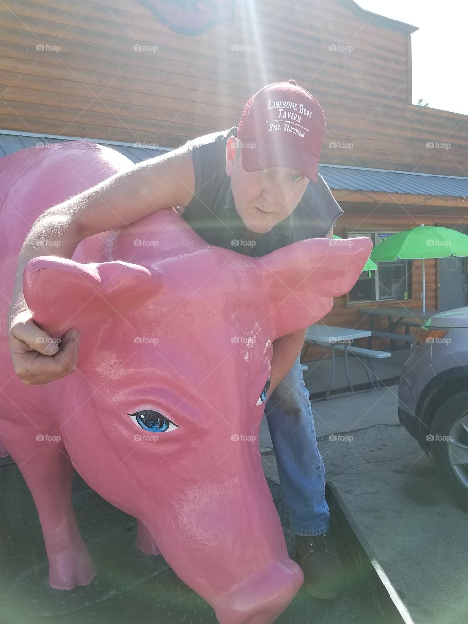 Man standing with piggy sculpture