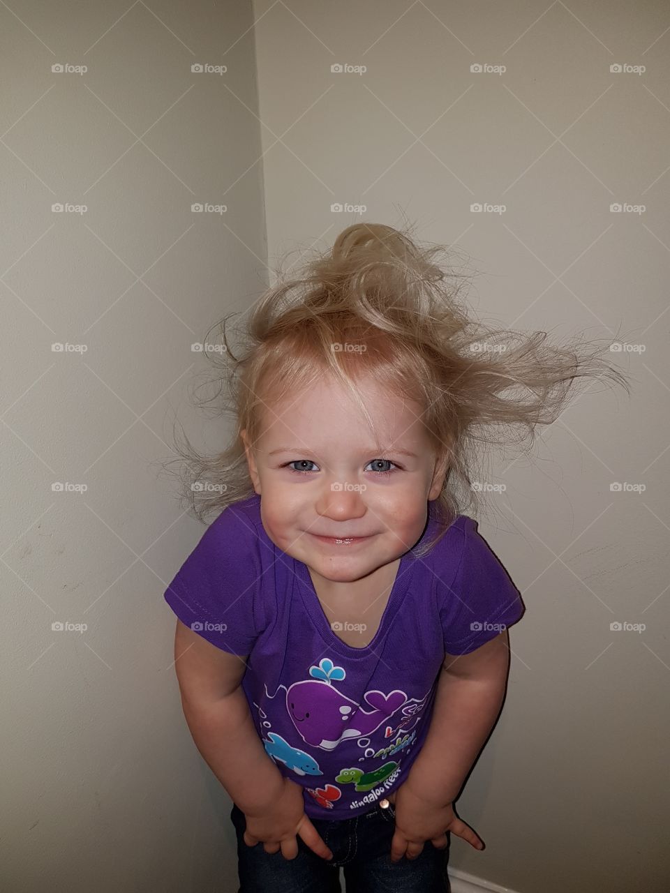Smiling little girl with messy hair sticking out