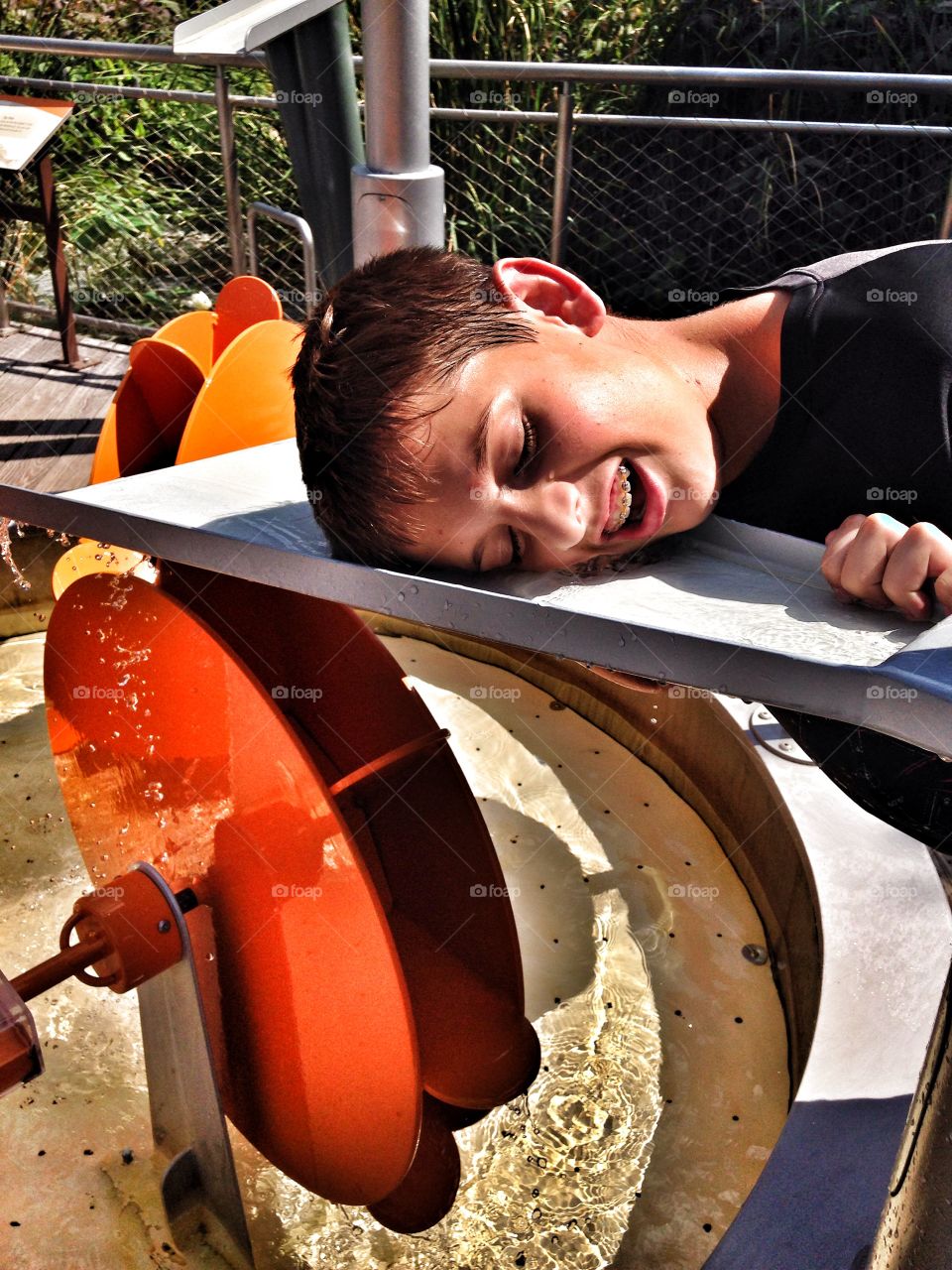 One way to cool off. Boy cooling off in outdoor water play exhibit