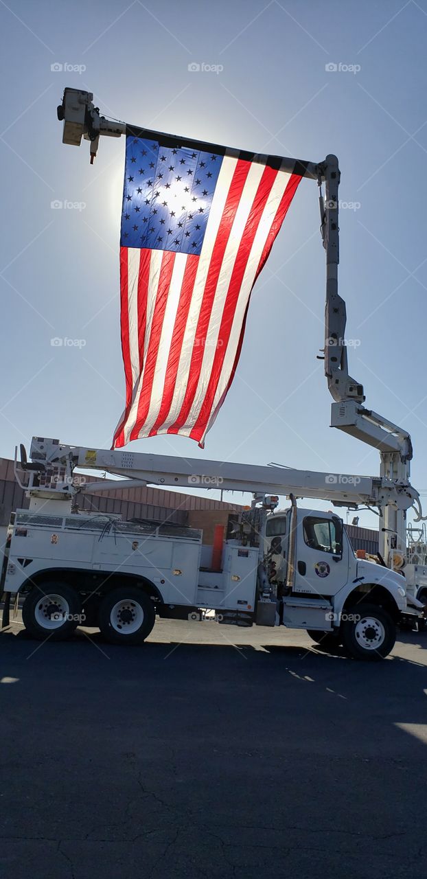 sun. flag and a bucket truck