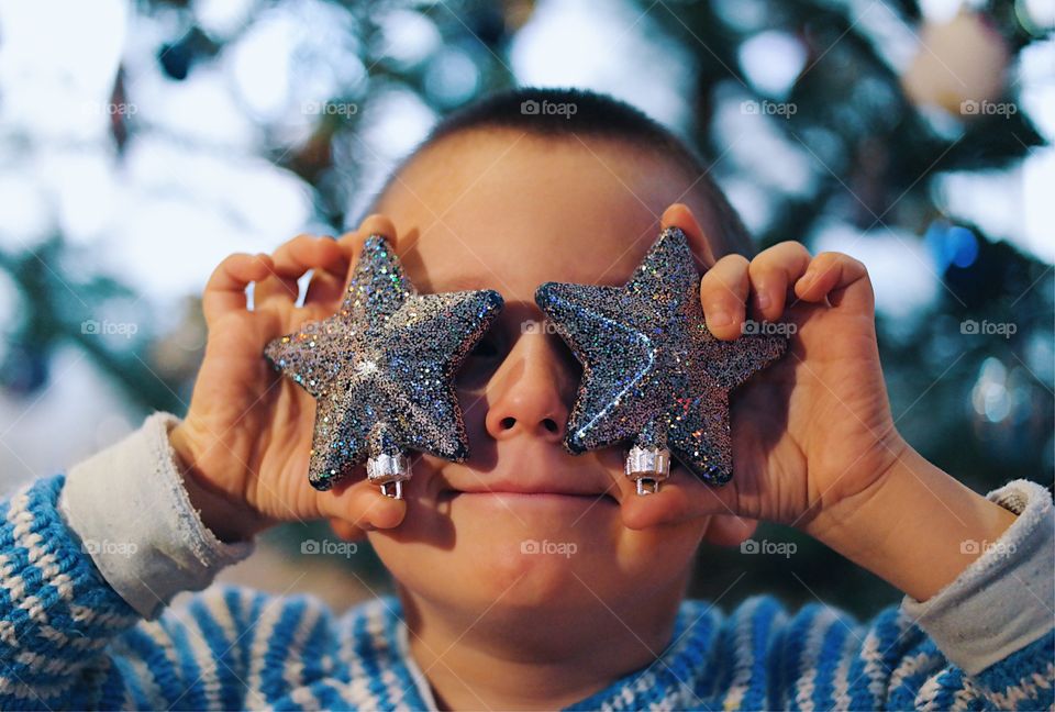 Boy hiding his eyes with lighting equipment