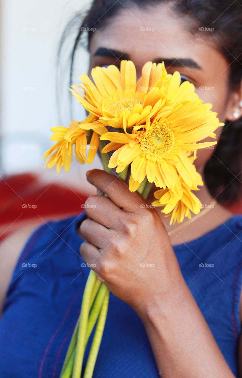 girl holding yellow flowers