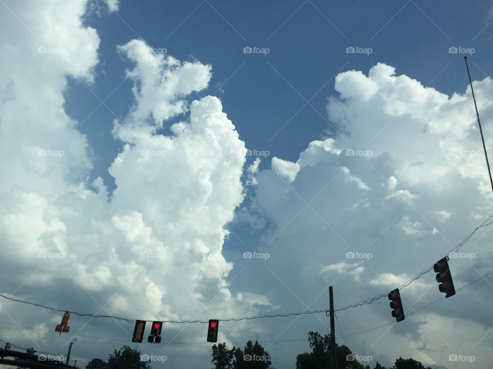 View of fluffy clouds and traffic lights