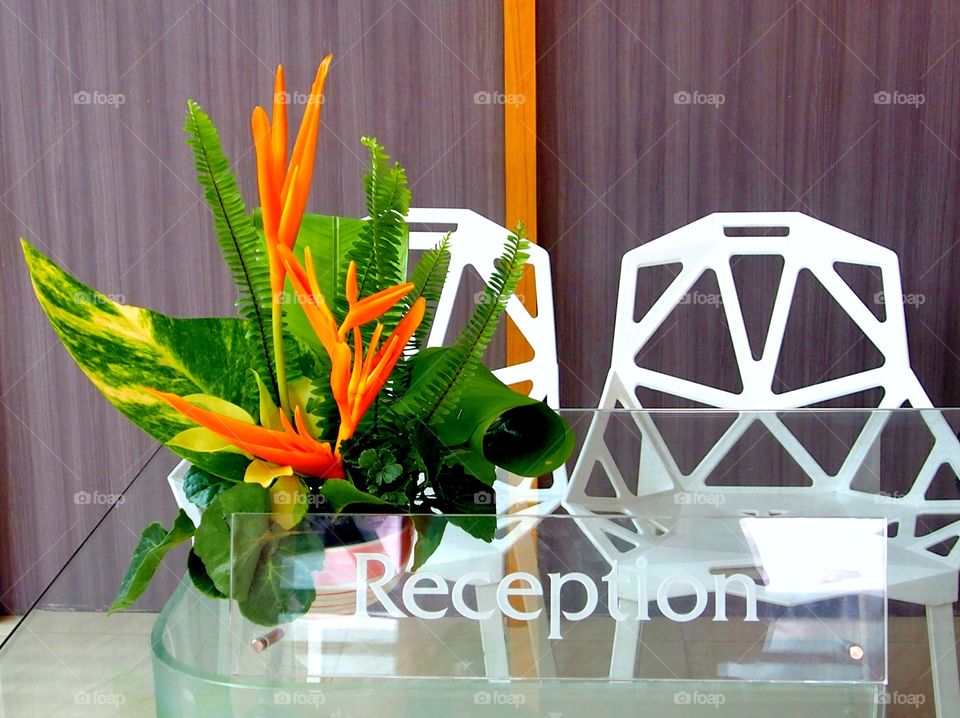 Flower and leaves in vase on reception desk