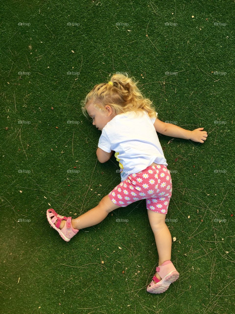 Elevated view of a little girl sleeping on grass in park