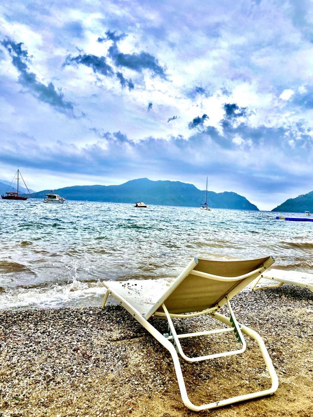 The photo shows a lonely sun lounger standing on a deserted beach. The landscape looks idyllic, inviting you to relax and contemplate natural beauty.