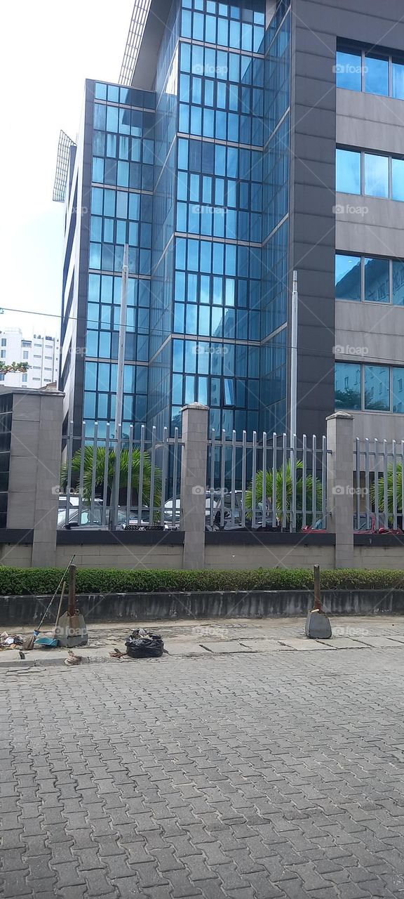 Beautiful modern office skyscraper buildings with surrounding landscape of green plants, well- trimmed.