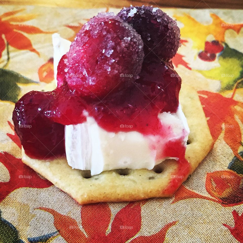 Cranberry Brulee on top of brie cheese on a whole wheat cracker