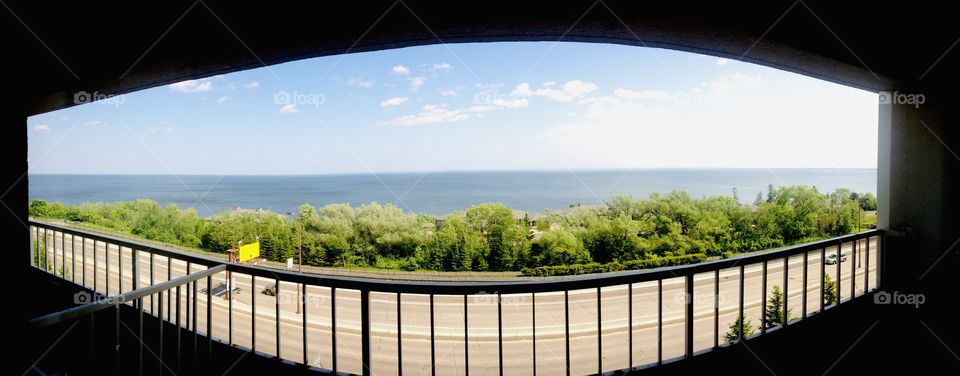 Very fun and interesting view out of a building includes rectangular fencing overlooking the ocean. 