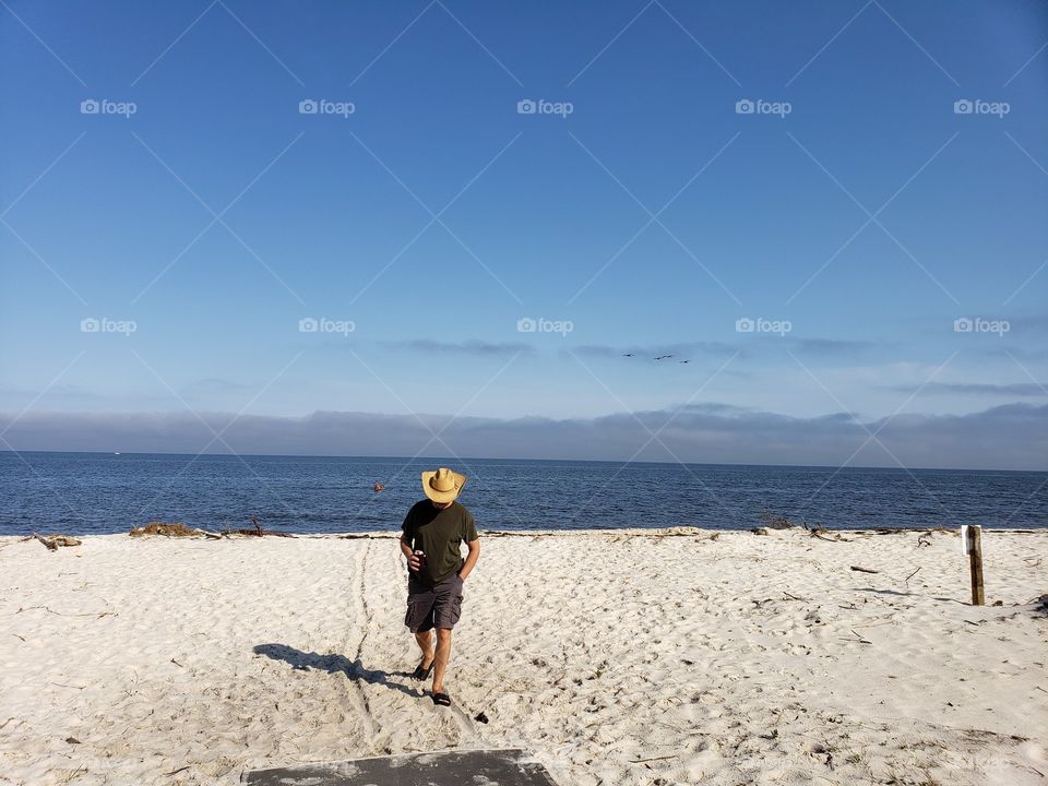 Man walking on beach on a sunny day