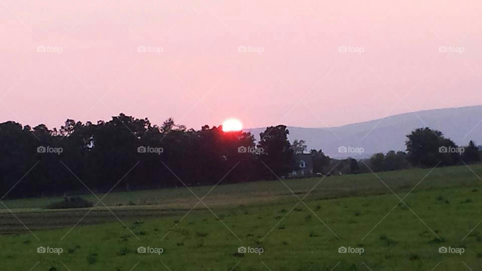 Mountain sunset. Colorful sun setting over the mountain top