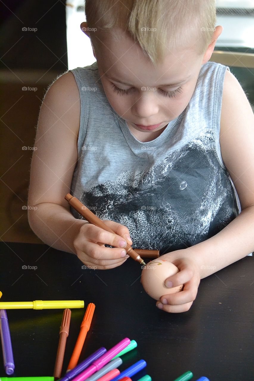 Boy painting egg