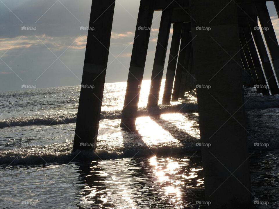 Sunshine glistening on the ocean and casting shadows. Johnnie Mercer's Pier.