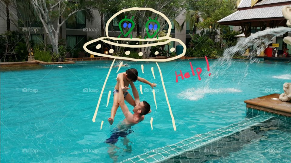 Anduction by the aliens versio. father and son having fun at the pool