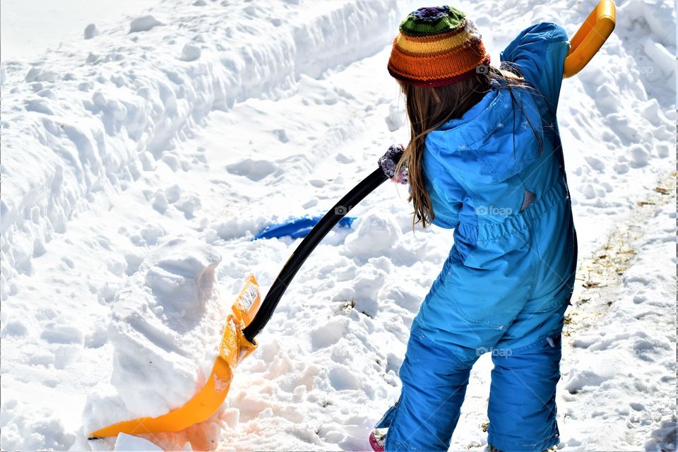 little girl shoveling snow