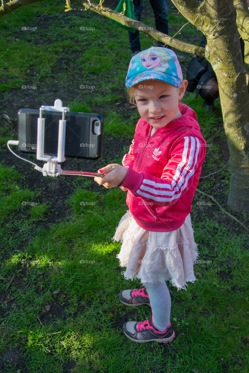 Young girl using a selfiestick to take a selfie in Lund Sweden.
