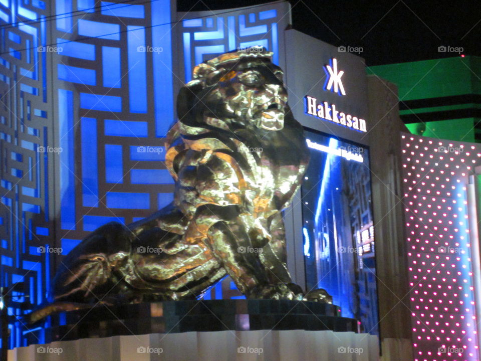 Golden Lion Statue, Hakkasan, Las Vegas, Nevada.  Electric Blue 
Lights in a Night View of The Strip