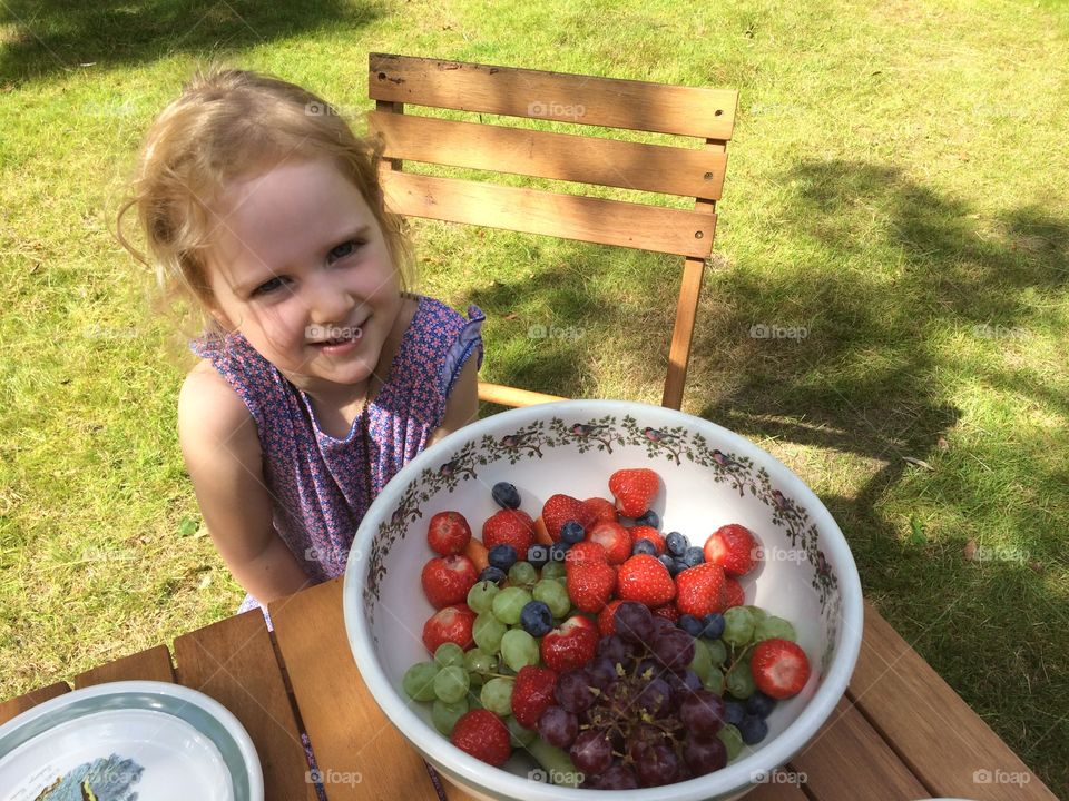 Bow of fresh fruits in front of a cute baby