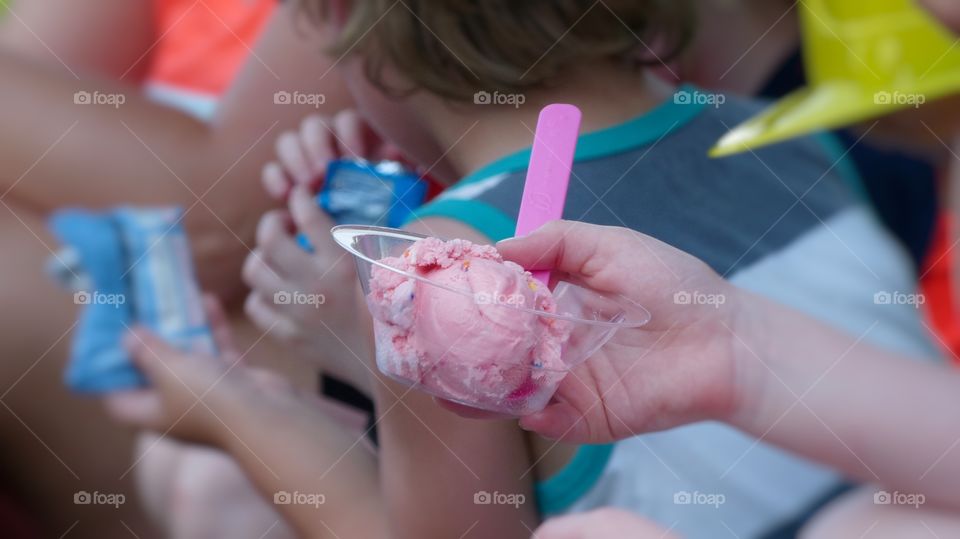 Child holding ice cream in a cup