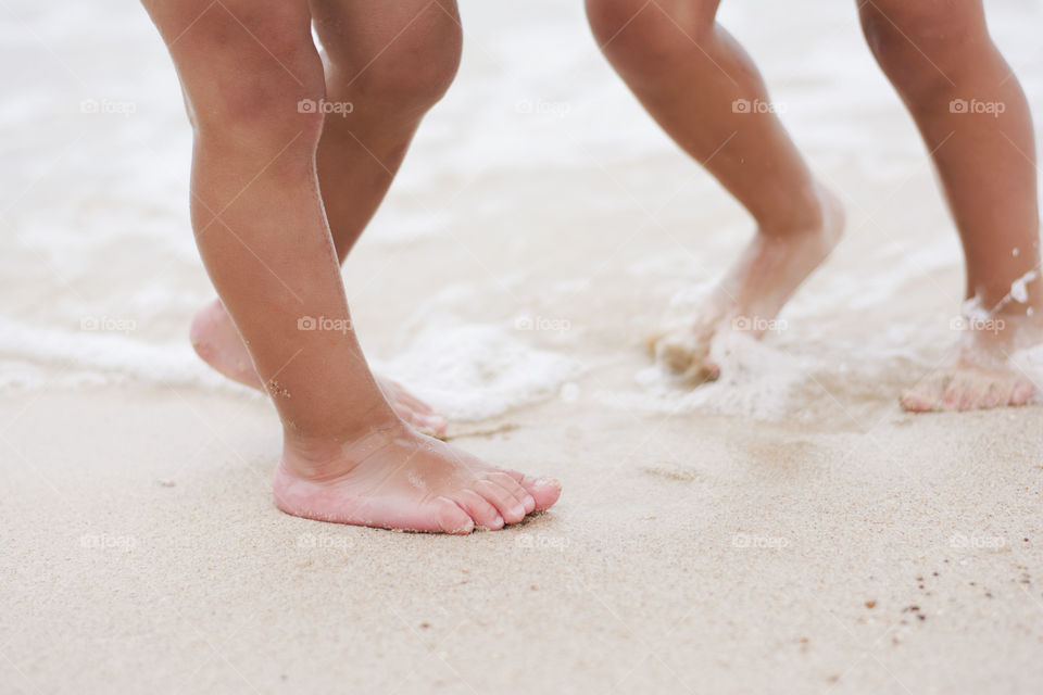 barefoot children on beach. barefoot children playing in the water on sandy beach