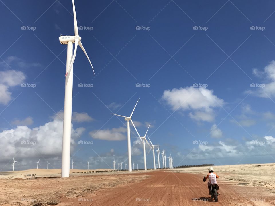 Man riding Motorbike crossing Wind turbines