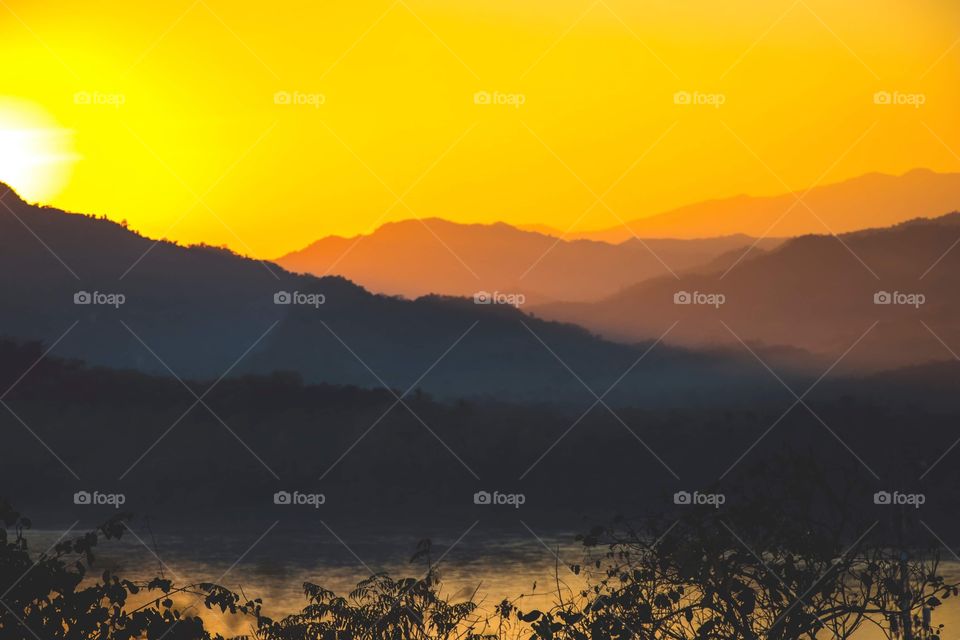Sunset over the mountain jungles in Luang Prabang, Laos at the golden hour.