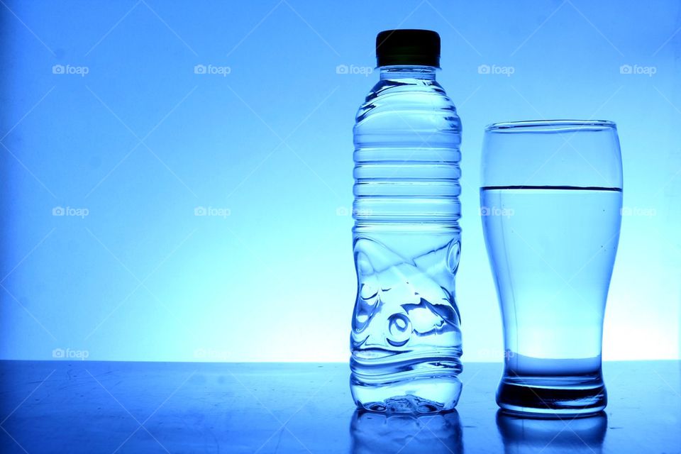 drinking water in plastic bottle and glass