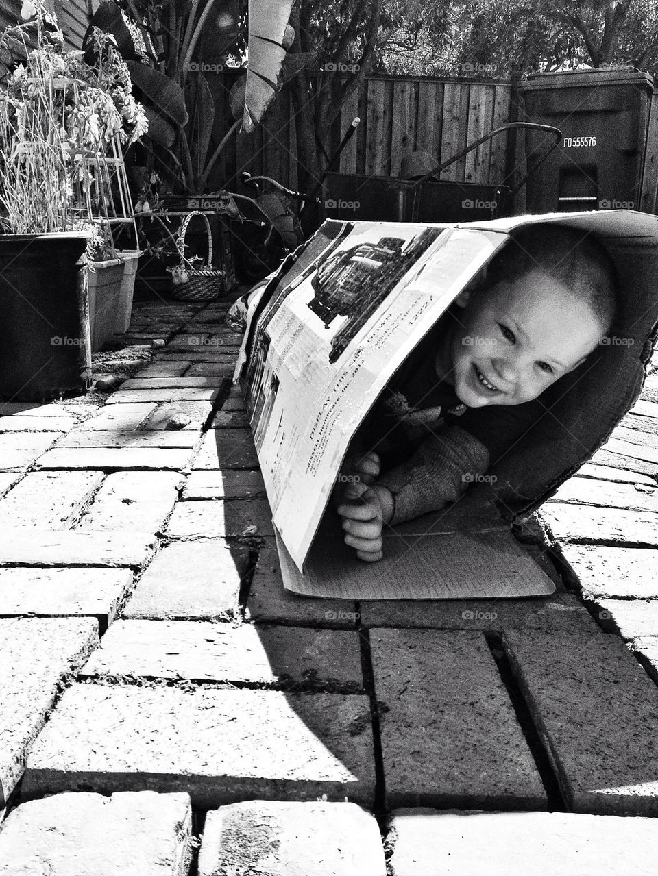 Boy joyfully playing in a cardboard box