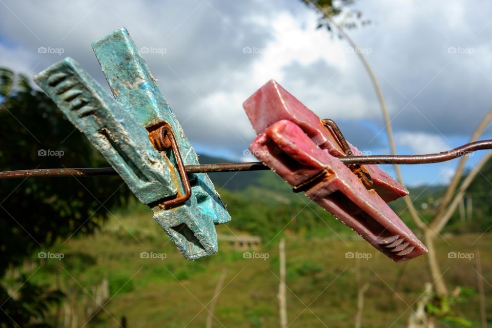 Two aged clothespin as friends on a clothes line
.
Two old and weary clothespin as friends on an outdoors clothes line in a tropical setting in Manicaragua, Cuba on Christmas eve 2013.