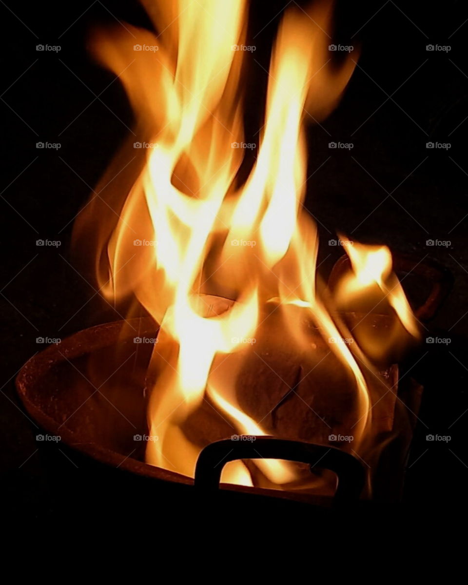 "Fire"

Someone burnt pappers in the pan.
It results such photo; yellowish whitish fire with dark background.