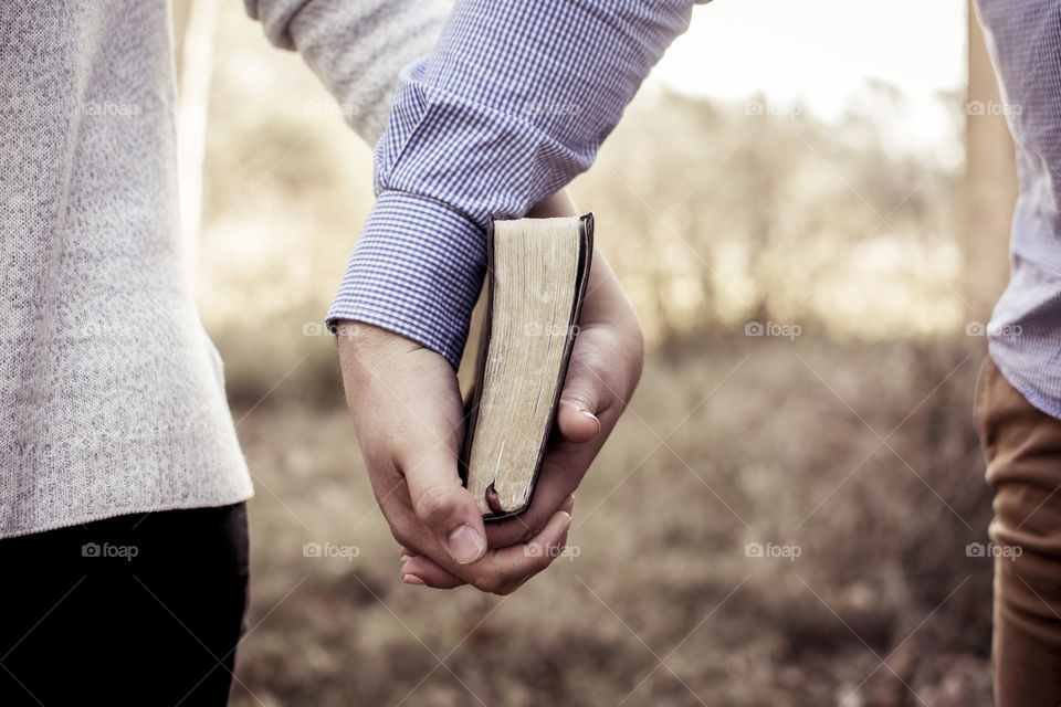 Hands of lovers holding book