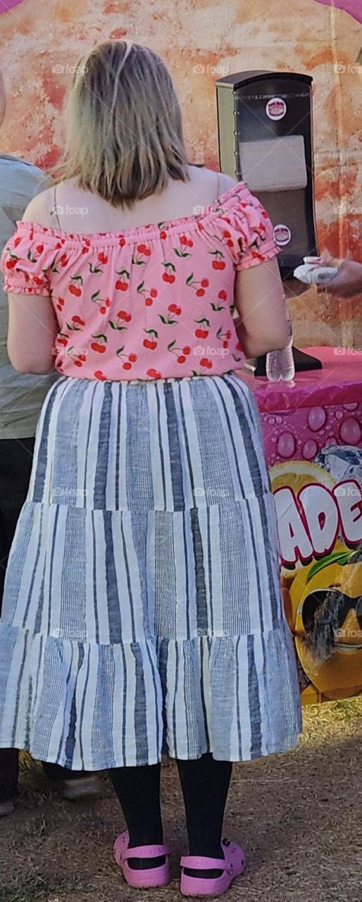 woman wearing a pink cherry pattern shirt at a concession stand for a county fair in Oregon