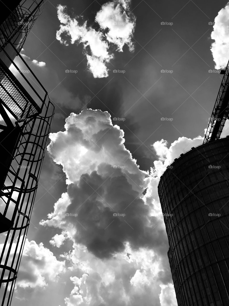Sunrise beaming out from behind  cumulonimbus clouds in Noir