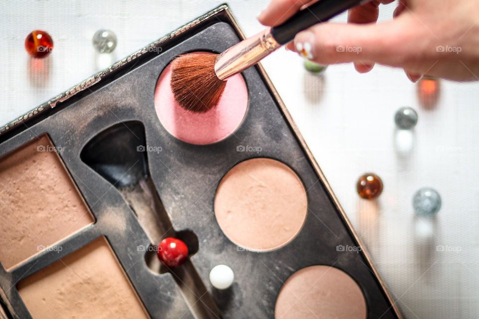 Makeup set and woman's hand with brush