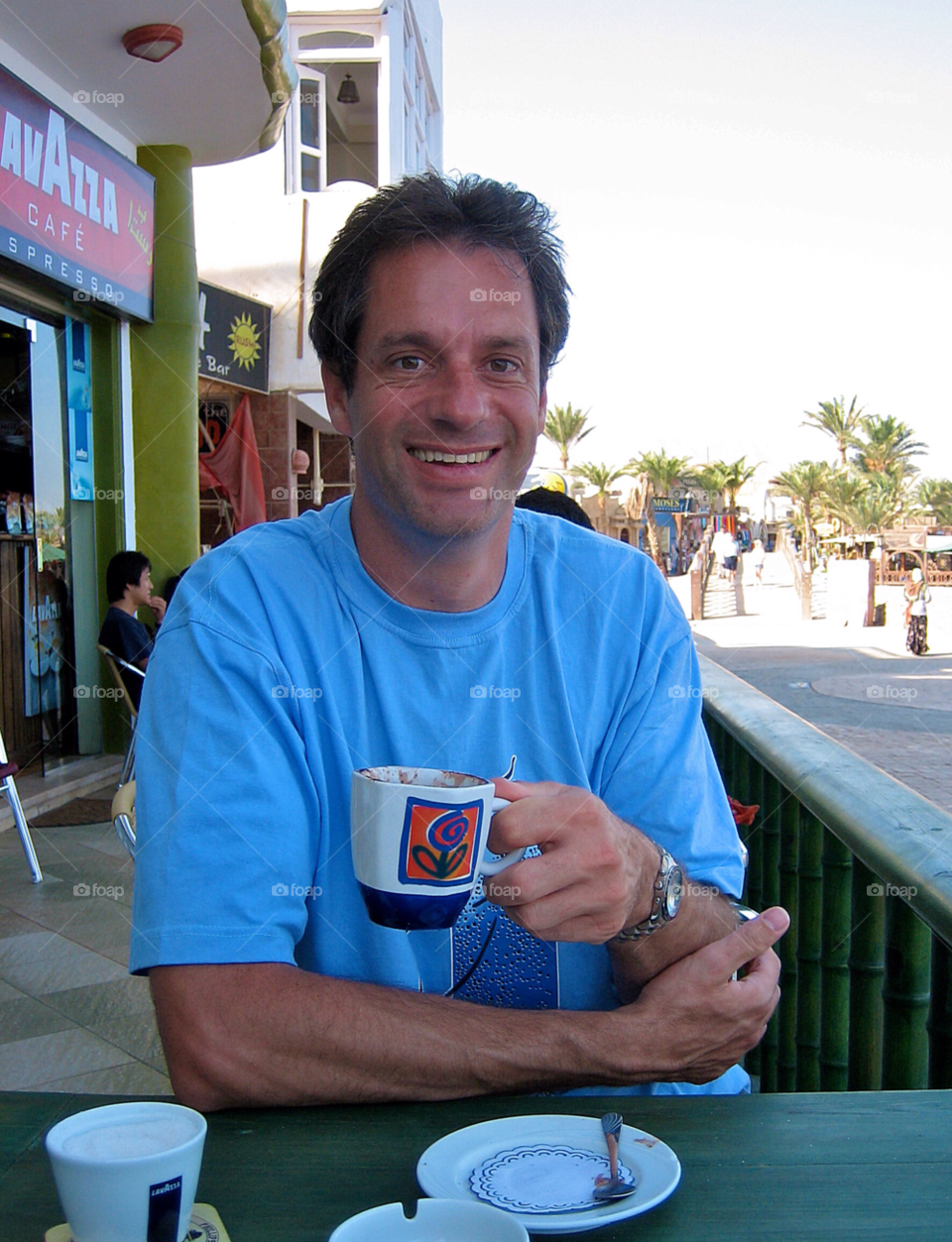 Man drinking coffee. Coffee break makes him smile 