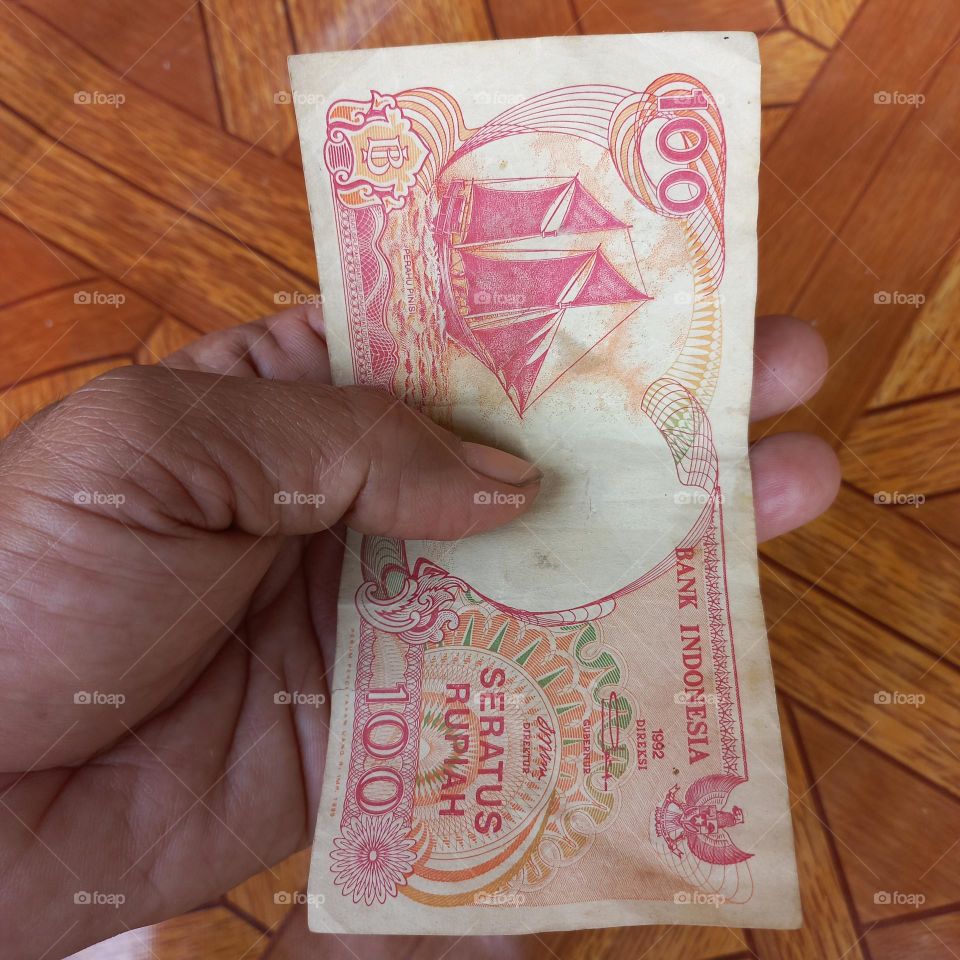 Old one hundred rupiah banknotes in hand