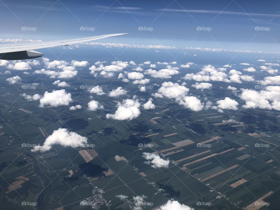 Great shot of the sky,clouds and land from an airplane above the agricultural lands of the province of Quebec in Canada 