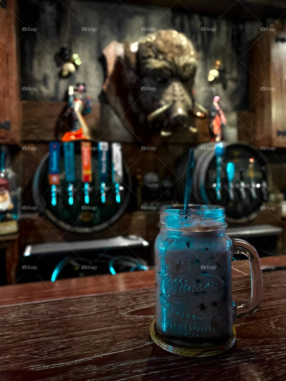 Blue cocktail in a bar with wild boar's head