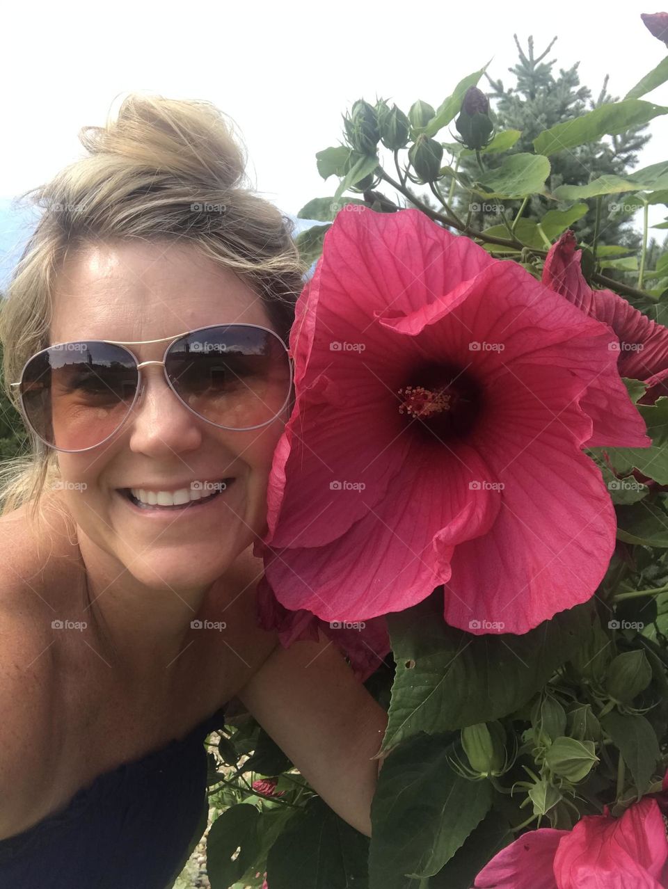 Selfie with large pink hibiscus flower