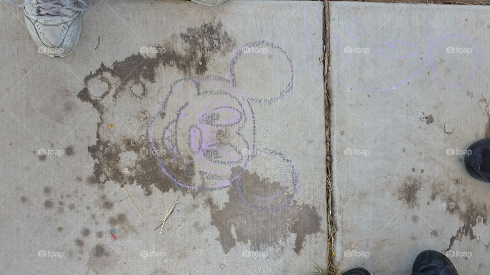 spilled soda and Mickey Mouse  chalk art on concrete