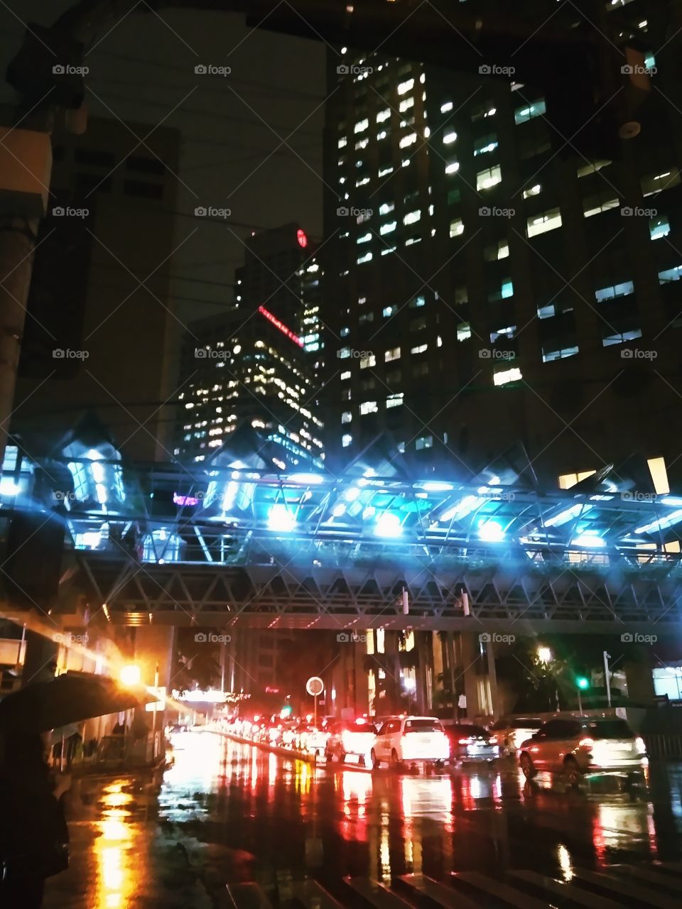 Bright lights in the City on rainy days are awesome. The reflection of light through the wet road and the blue light from the bridge are interesting. This busy City of Makati is beautiful.