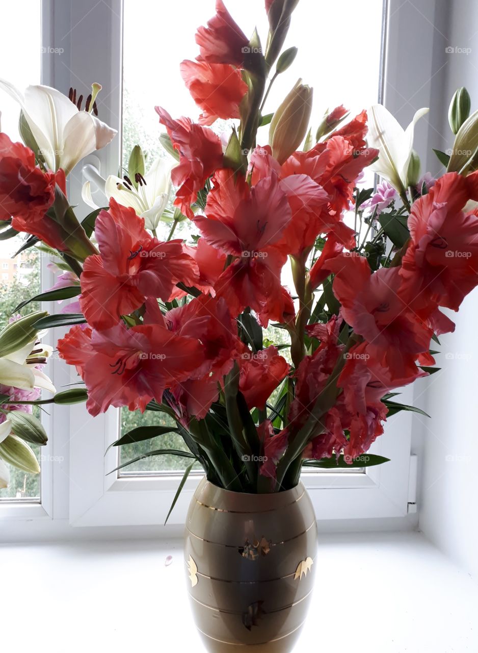 Vase with a buquet of gladiolus and lilies