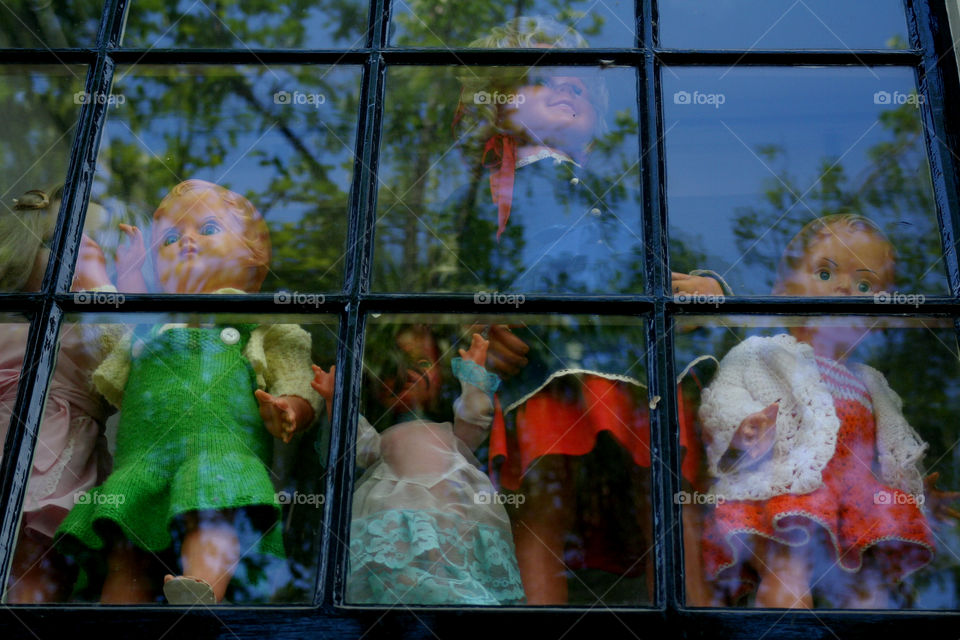 Vintage dolls behind a window